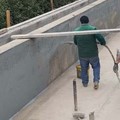 Swimming pool sealing with cementitious elastomer mortar with a special launching machine