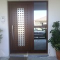 Πόρτα αλουμινίου σε χρώμα ξύλου, με στοιχείο inox και σταθερό καθρεπτιζόμενο τζάμι