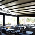 Remotely controlled awning pergola, with vertical rideau curtains and a special triangular frame