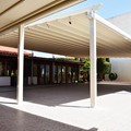 Awning-pergola structure with sockets for interior LED lighting and an assembled traditional gutter along the parapet